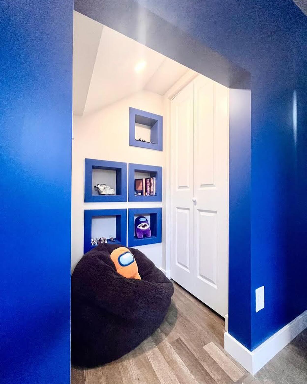 Winnipeg basement kids bedroom with bold blue shelving, under-stair storage, and a reading nook