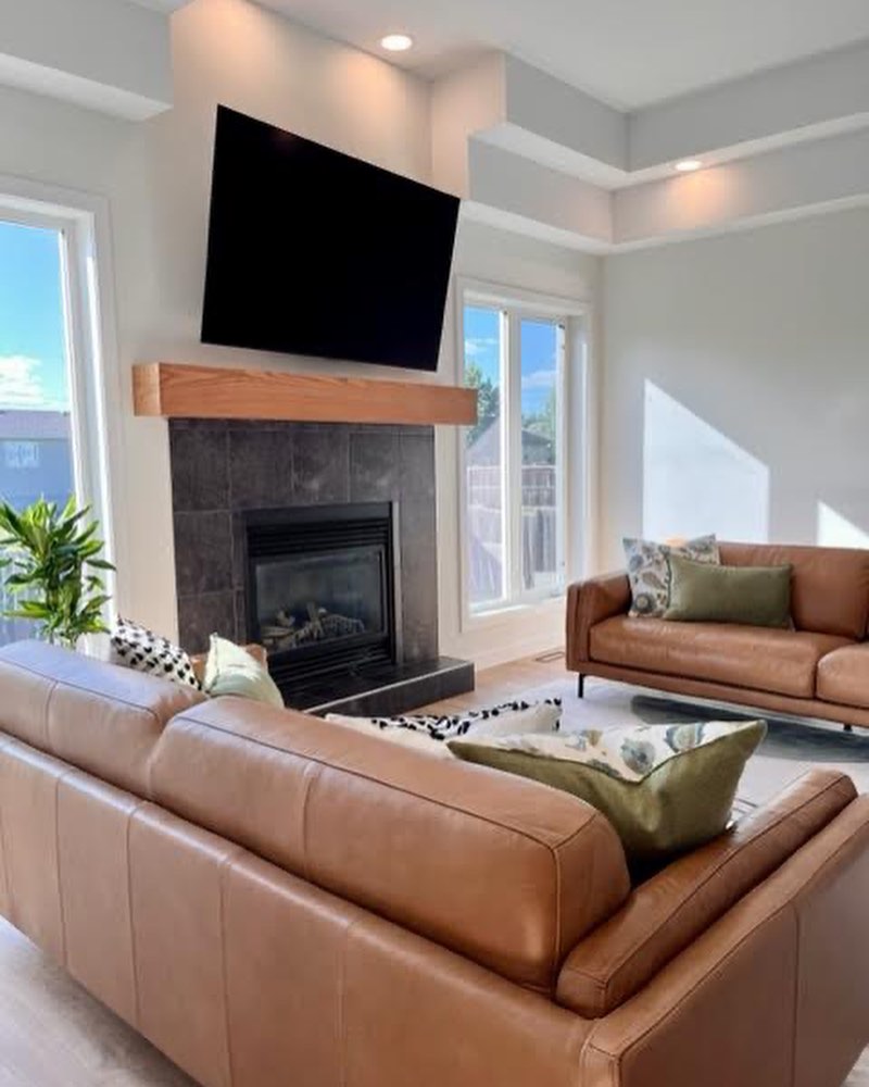 Refreshed Winnipeg living room fireplace wall with custom mantle and mounted TV