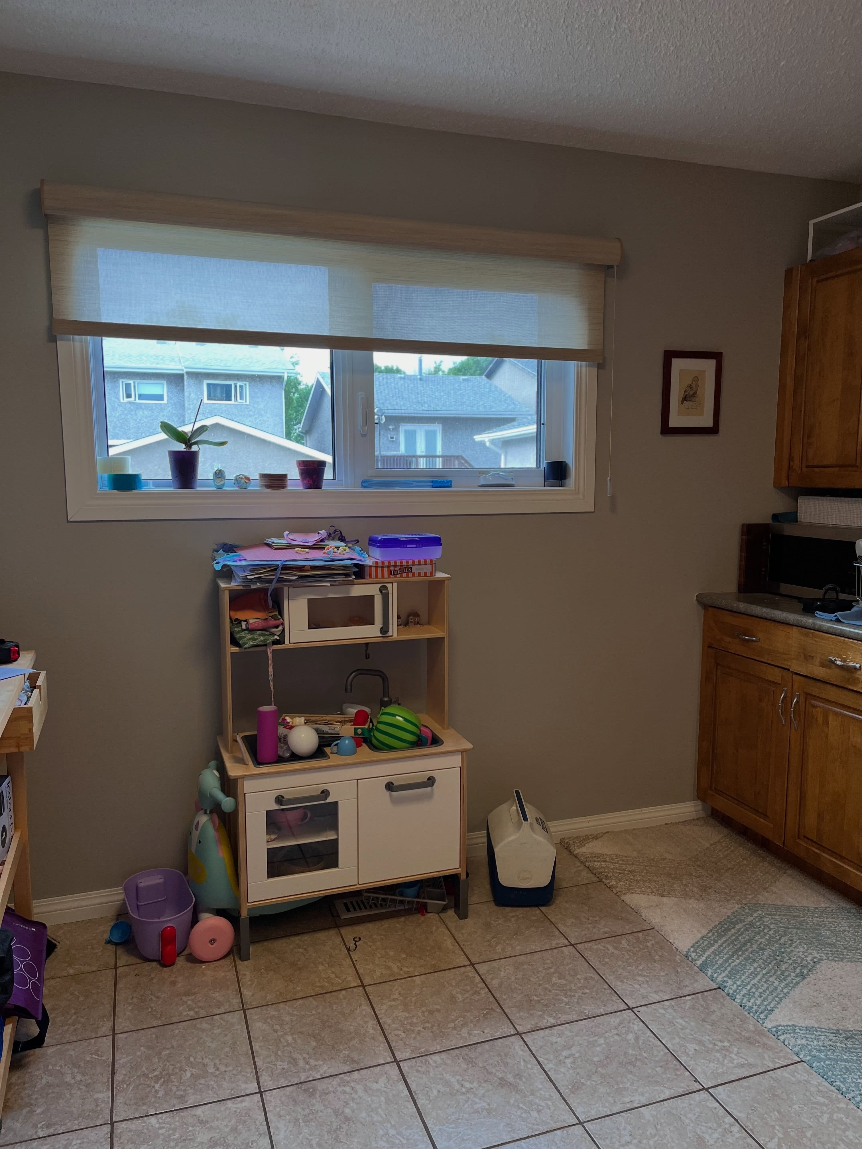 Winnipeg kitchen before renovation looking toward the window with toys and older oak cabinets visible