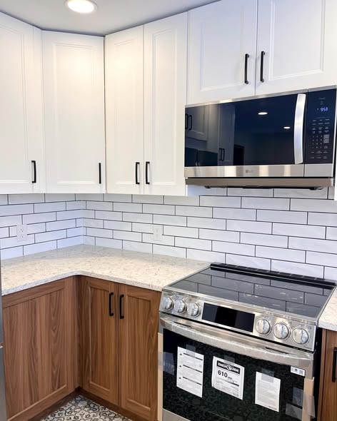 Finished Project Hydrangea range wall with wood lower cabinets, white uppers, subway tile, and a stainless slide-in range